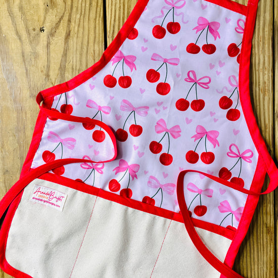 Amanda Bright Designs Children's Cherries and Bows Apron with red trim and strings trending