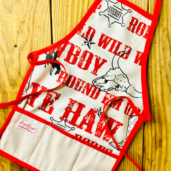 Amanda Bright Designs Jane Apron Children's Cowboy Print Giddy Wild West Horse Spurs Boots with Red Apron Strings and Three Pockets