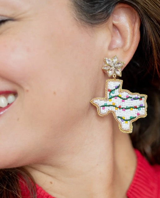 Earring shaped like Texas with Christmas lights worn by a person