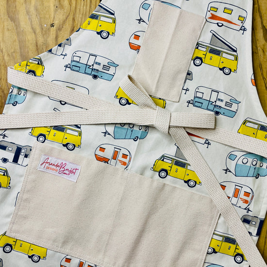 Amanda Bright Designs apron with camper and van pattern on a wooden surface