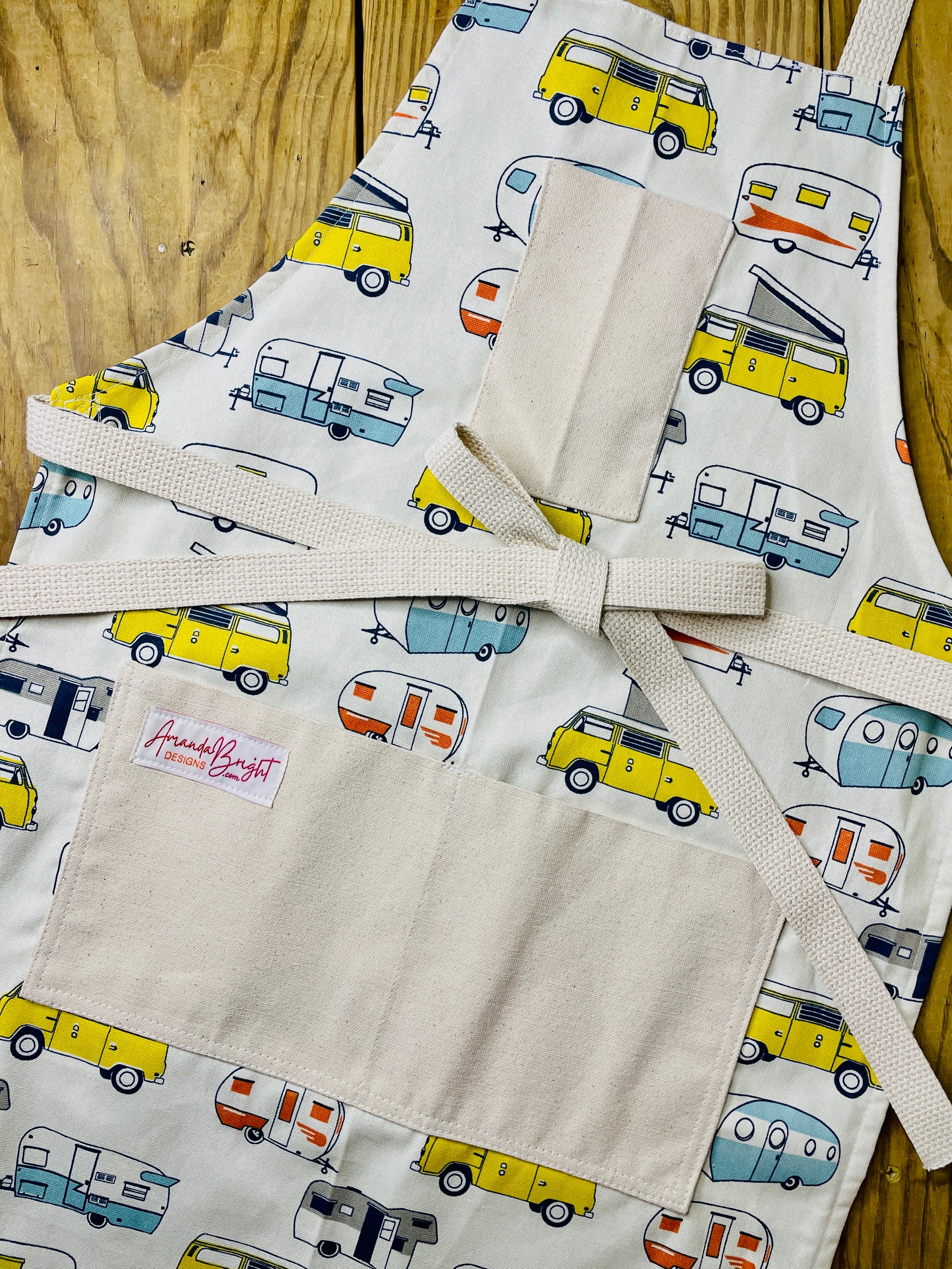 Amanda Bright Designs apron with camper and van pattern on a wooden surface