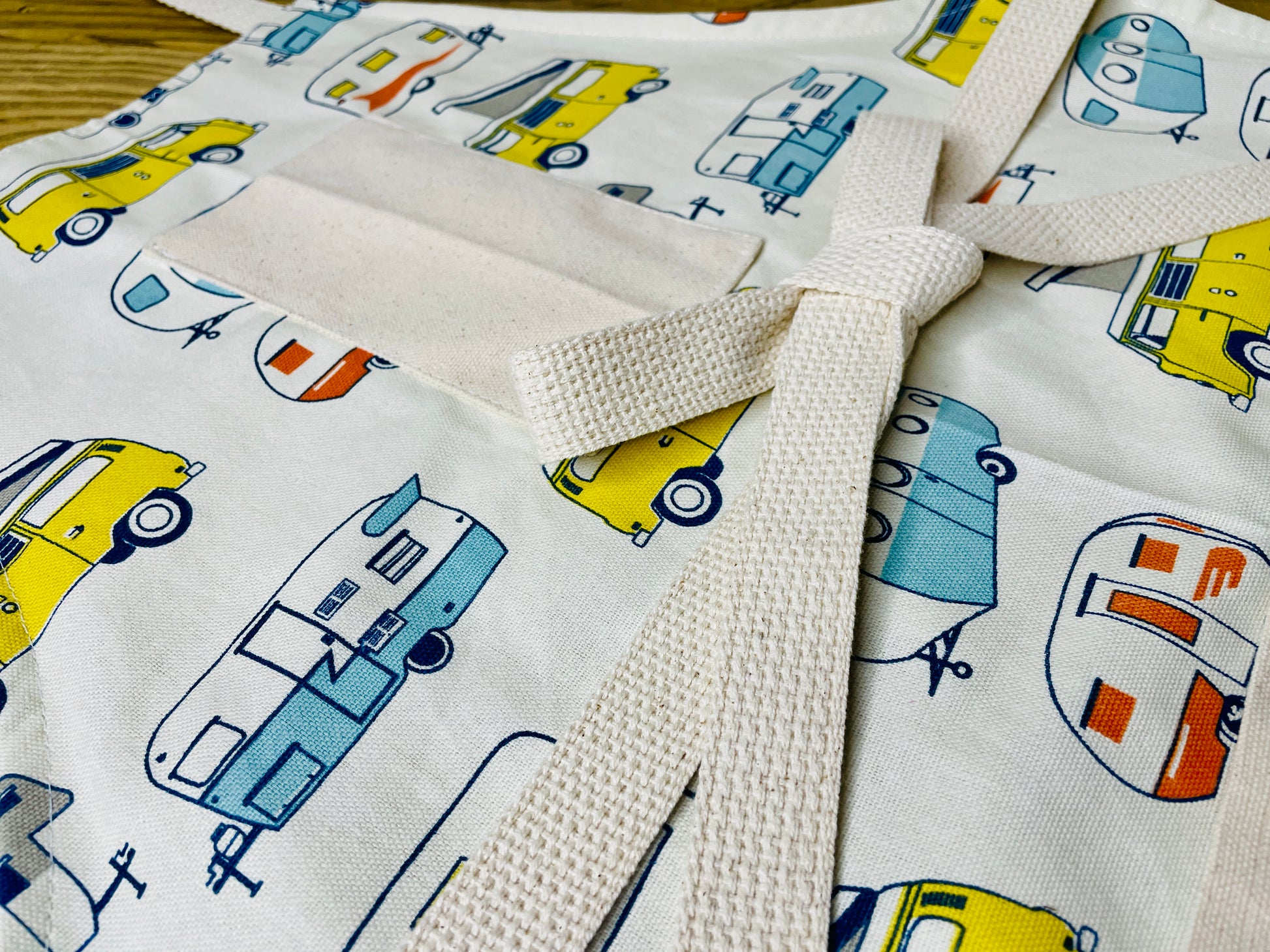 Amanda Bright Designs apron with camper and van pattern on a wooden surface
