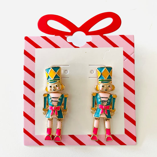 Amanda Bright Designs Pair of nutcracker-themed earrings on a red and white striped card.