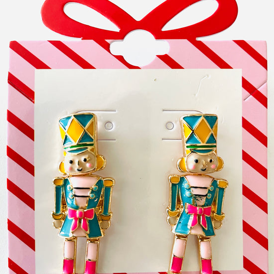 Amanda Bright Designs Pair of nutcracker-themed earrings on a red and white striped card.