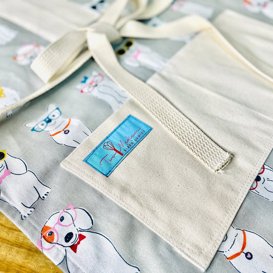 Two Medium Sized Ladies Coco Apron Little white dog fanatic dress up sunglasses hair bow neckties close up view