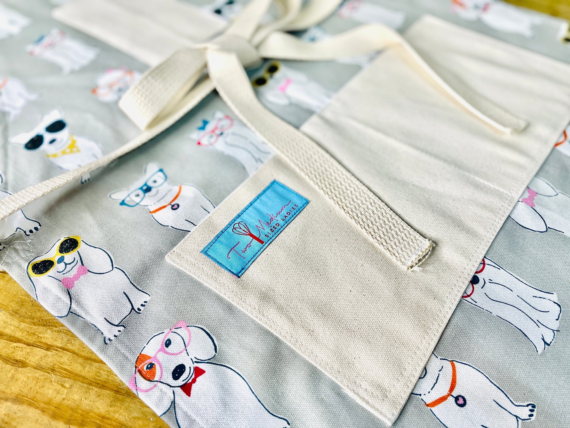 Two Medium Sized Ladies Coco Apron Little white dog fanatic dress up sunglasses hair bow neckties close up view