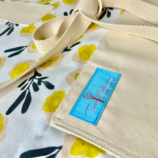 Two Medium Sized Ladies Rebecca vintage mod apron yellow flowers lack foliage midcentury retro designer vibe baking cooking gardening crafts apron close up view