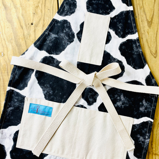 Two Medium Sized Ladies Susanna Apron cowhide black and white holstein Susanna Dickinson Lady of the Alamo modern farmhouse style kitchen