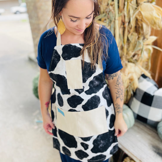 Two Medium Sized Ladies Susan Apron cowhide black and white holstein Susanna Dickinson Lady of the Alamo model wearing apron